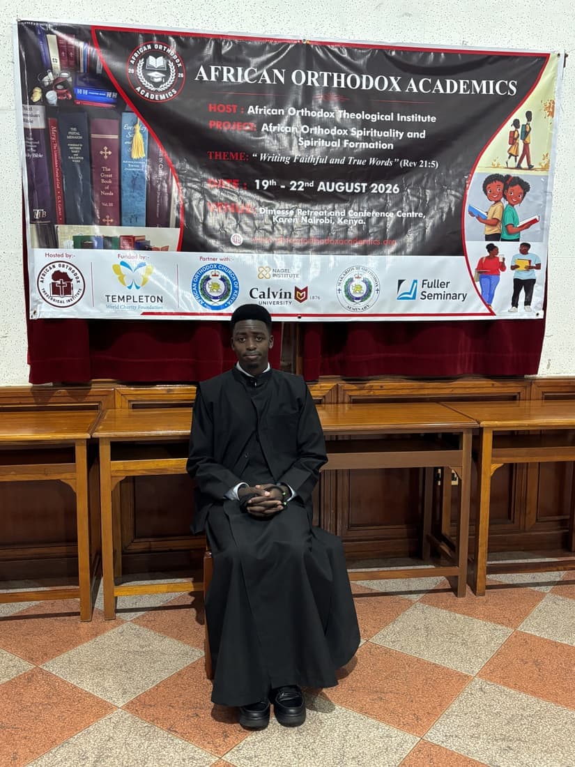 A participant photographed beside the African Orthodox Academics banner.