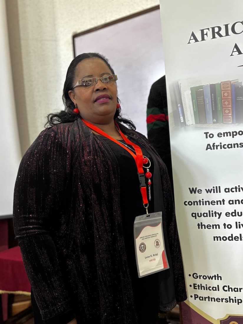 A participant photographed beside the African Orthodox Academics banner.