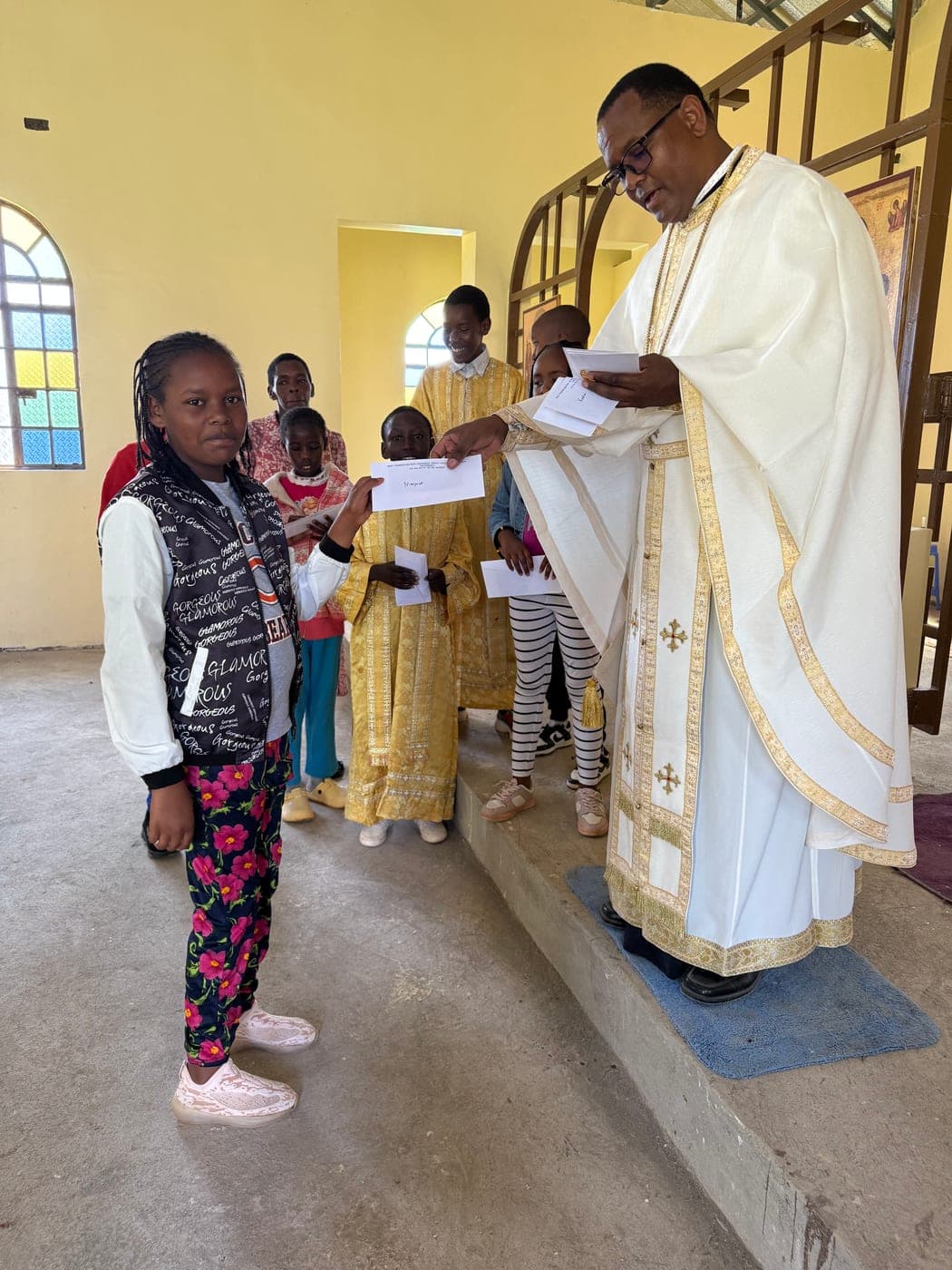 A secondary-school pupil receiving her award letter from Fr Thiani.