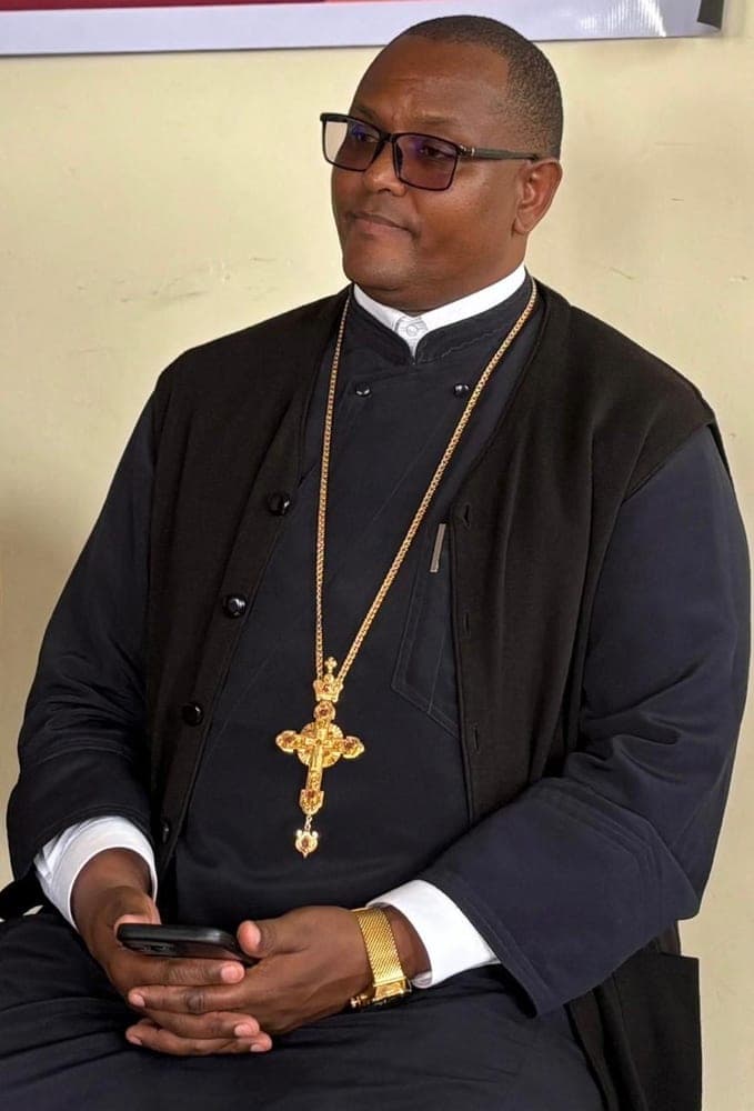 Fr Dr Evangelos Thiani seated, wearing a cassock and pectoral cross.