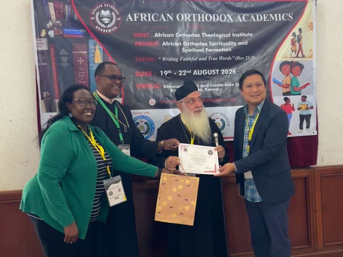 A certificate presented in front of the workshop banner — African Orthodox Academics, on the theme “Writing Faithful and True Words”, 19th to 22nd August 2026 in Karen, Nairobi.